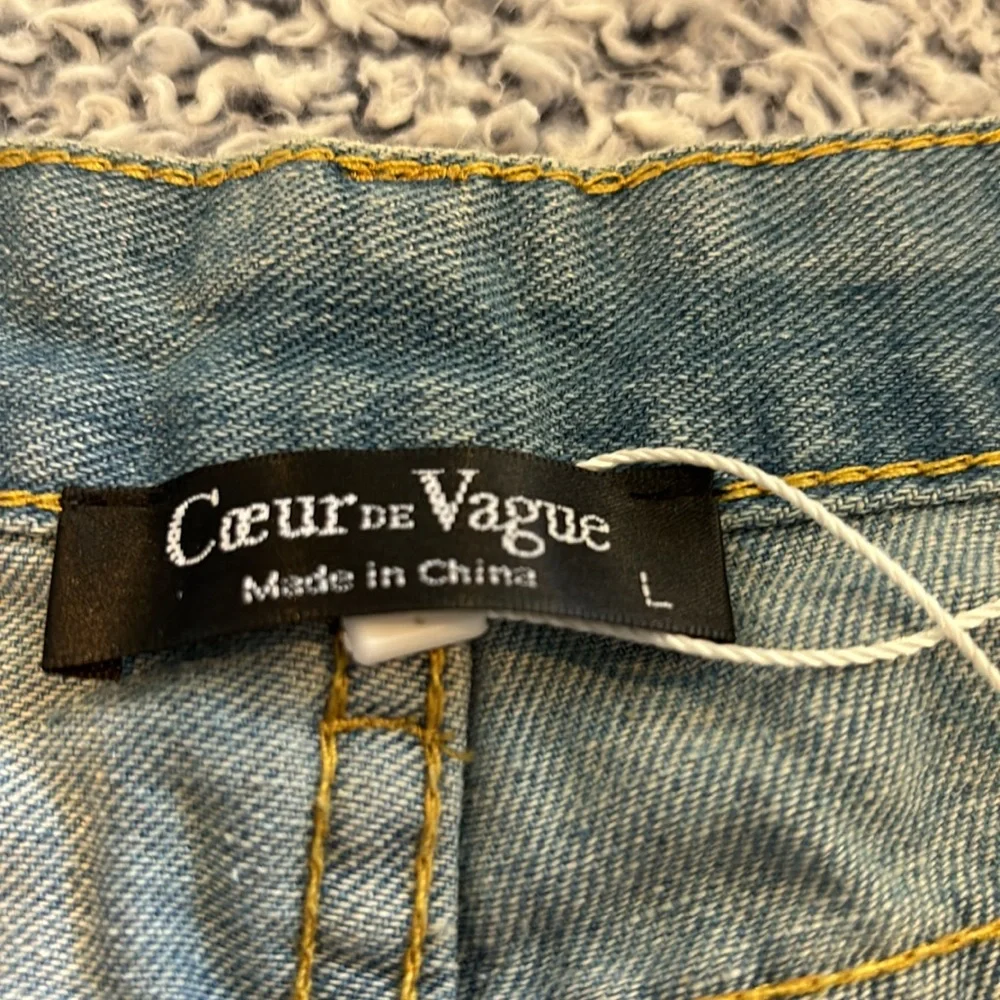 Large light blue soft denim cuffed jean shorts with shredded holes. - Picture 2 of 4